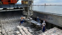 Sejumlah pekerja memindahkan karung semen ke atas kapal di dermaga Semen Padang, Teluk Bayur, Padang, Sumatera Barat.