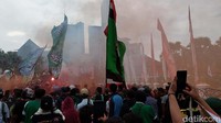 Massa datang membawa atribut bendera dan flare warna merah serta biru, serta baju bertuliskan Persebaya.