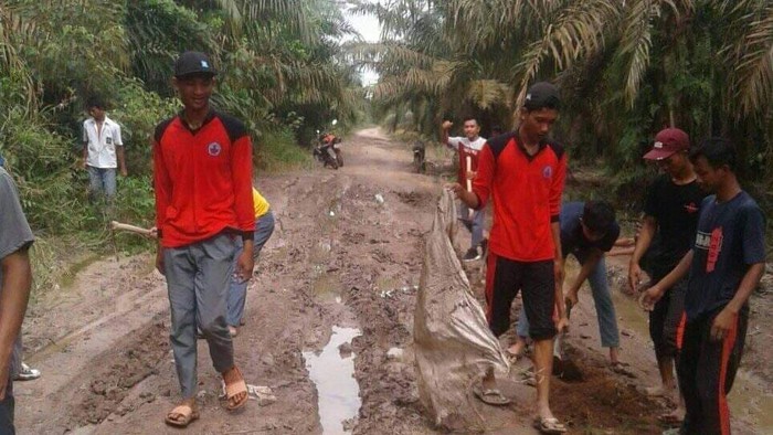 Siswa SMA Negeri 1 Pulau Rimau, Banyuasin, Sumsel, gotong royong perbaiki jalan berlumpur akses menuju ke sekolahnya. (Dok. Istimewa)