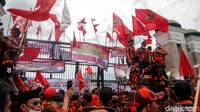 Berbagai poster tuntutan dipasang di pagar gedung DPR. Sementara itu, polisi berjaga di dalam dan luar gedung DPR.
