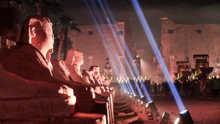 This picture taken on November 25, 2021 shows a view of the human-headed sphinxes along the 2700-metre-long Rams Road leading from the Temple of Luxor (background) to the Karnak Temple (unseen) further north, in Egypts southern city of the same name. - Egypt on November 25 unveiled in a grandiose night-time ceremony the Rams Road (Tareeq al-Kebbash in Arabic), a 2700-metre-long sandstone-paved path lined with ram-headed statues and sphinxes dating over 3000-years-old connecting the Luxor Temple with the Karnak Temple. Named The Path of God in Ancient Egyptian mythology, its ram statues -- an embodiment of the ancient Egyptian deity Amun -- were buried for centuries under the sand before being revived and restored for display in recent years. (Photo by Khaled DESOUKI / AFP)