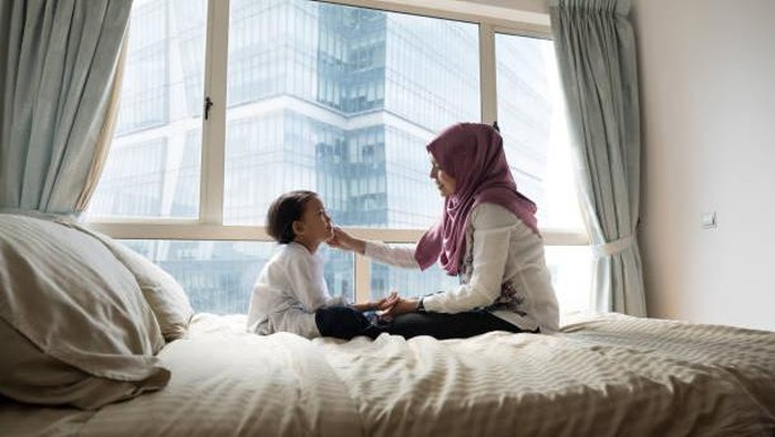 A mother gets her daughter ready for school