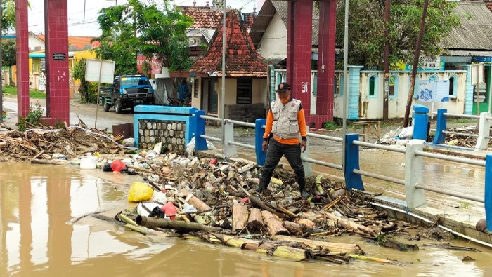 hujan di Lamongan membuat Sungai Mengkuli yang melintasi Desa Balun, Kecamatan Turi menggenangi jalan desa dan pemukiman warga
