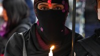 Seorang perempuan memegang lilin saat demonstrasi memperingati Hari Internasional Penghapusan Kekerasan terhadap Perempuan di Quito, Ekuador, Kamis (25/11/2021). Setiap tahunnya, peristiwa ini diperingati dengan mengangkat tema yang berbeda. AP/Dolores Ochoa  