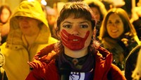 Seorang wanita muda dengan wajah dilukis dengan cetakan tangan, berbicara, selama demonstrasi menuntut lebih banyak tindakan pemerintah untuk mencegah kekerasan terhadap perempuan, di Bayonne, Prancis barat daya, Kamis (25/11/2021). Aktivis hak-hak perempuan telah mengakui 25 November sebagai hari untuk memerangi kekerasan berbasis gender sejak tahun 1981. AP/Bob Edme  