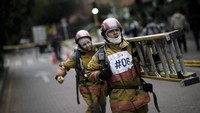 Petugas pemadam kebakaran pria dan wanita menjalankan rintangan untuk mempromosikan kesetaraan gender, di Bogota, Kolombia, Kamis (25/11/2021). AP/Ivan Valencia  