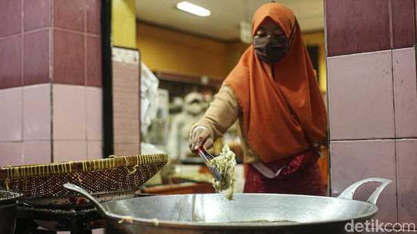 Seorang karyawati toko tampak sibuk menggoreng tempe mendoan jumbo dan keripik tempe di kawasan Sawangan.