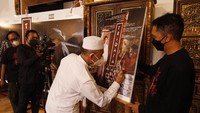 Pengasuh Pesantren Kauman Lasem KH Zaim Ahmad Mashoem atau Gus Zaim (kedua kanan) didampingi Kurator Galeri Foto Jurnalistik Antara (GFJA) Ismar Patrizki (kanan) dan tokoh Yayasan Lasem Heritage Baskoro Pop (kiri) menandatangani poster Pameran Fotografi Tridaya saat pembukaan di Rumah Merah,Desa Karangturi, Lasem, Rembang, Jawa Tengah, Kamis (25/11/2021). ANTARA FOTO/Maulana Surya