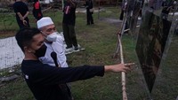 Kurator Pameran Fotografi Tridaya Ismar Patrizki (kiri) menjelaskan tentang foto yang dipamerkan kepada Pengasuh Pesantren Kauman Lasem KH. Zaim Ahmad Mashoem (kedua kiri) pada Pameran Fotografi Tridaya di Rumah Karangturi 20, Desa Karangturi, Lasem, Rembang, Jawa Tengah. ANTARA FOTO/Harviyan Perdana Putra