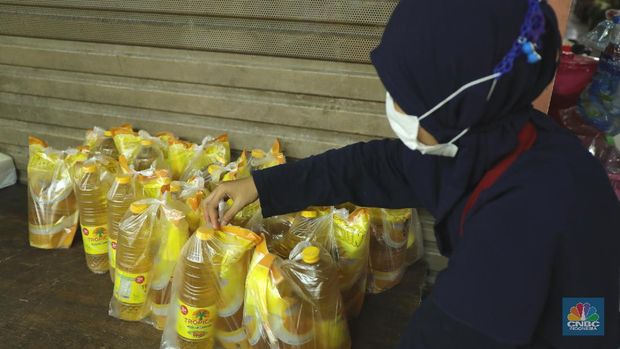 Ratusan warga antre untuk mendapatkan minyak curah kemasan di salah satu pasar di Jakarta, Jumat (26/11/2021). Program yang dilakukan oleh Pasar Jaya berkerja sama dengan Bank DKI berupa Rp. 20.000 ribu subsidi mendapatkan 2 liter + bonus 1 liter minyak curah. Sebelumnya, warga harus menginstal aplikasi Jakone  dan mengikuti persyaratan yang tertera di aplikasi. Suherman salah satu pedagang gorengan mengatakan 