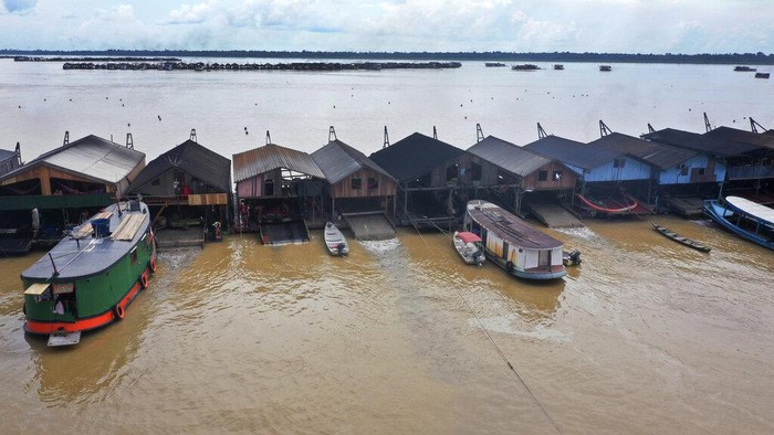 An illegal gold miner fixes a machine on a dredging barge on the Madeira river, a tributary of the Amazon river in Autazes, Amazonas state, Brazil, Thursday, Nov.25, 2021. Hundreds of mining barges have arrived during the past two weeks after rumors of gold spread, with environmentalists sounding the alarm about the unprecedented convergence of boats in the sensitive ecosystem. (AP Photo/Edmar Barros)