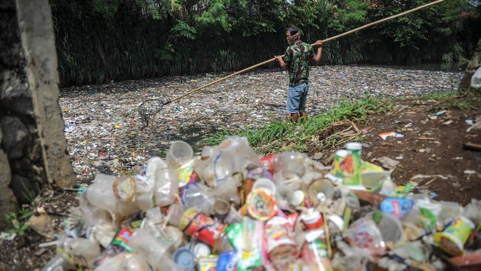 Warga mengambil sampah plastik di Sungai Bojong Citepus, Dayeuhkolot, Kabupaten Bandung, Jawa Barat, Jumat (26/11/2021). Menurut warga setempat, sampah yang tersendat di pertemuan antara Sungai Bojong Citepus dan Sungai Citerum tersebut menimbulkan bau tak sedap dan berharap agar dinas terkait segera membersihkan sampah itu. ANTARA FOTO/Raisan Al Farisi/hp.