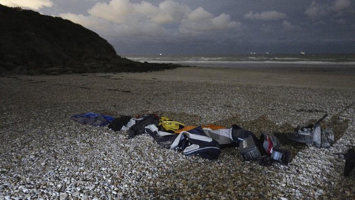 Life jackets, sleeping bags and damaged inflatable small boat are pictured on the shore in Wimereux, northern France, Friday, Nov. 26, 2021 in Calais, northern France. Children and pregnant women were among at least 27 migrants who died when their small boat sank in an attempted crossing of the English Channel, a French government official said Thursday. (AP Photo/Rafael Yaghobzadeh)