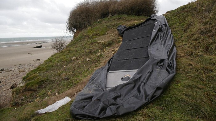 Sebrangi Selat Inggris, 27 Migran Tewas Tenggelam A damaged inflatable small boat is pictured on the shore in Wimereux, northern France, Thursday, Nov. 25, 2021 in Calais, northern France. Children and pregnant women were among at least 27 migrants who died when their small boat sank in an attempted crossing of the English Channel, a French government official said Thursday. French Interior Minister Gerald Darmanin also announced the arrest of a fifth suspected smuggler thought to have been involved in what was the deadliest migration tragedy to date on the dangerous sea lane.(AP Photo/Michel Spingler)