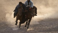 Para pemain Buzkashi menunggangi kuda bersaing memperebutkan kambing yang sudah disembelih dan berusaha membawa ke gawang di Herat, Afghanistan (26/11/2021).  Buzkashi merupakan olahraga budaya yang populer di Asia Tengah dan telah dimainkan sejak ratusan tahun lalu