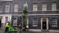 Halaman kantor PM Inggris di Jl Downing Street No.10, London, tak luput dari pohon natal. Tampak petugas menurunkan pohon cemara untuk menyambut natal, (26/11/2021). (AP Photo/Matt Dunham)