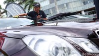 Peserta membersihkan mobil yang dipamerkan di Indonesia Automodified (IAM) x IIMS Motobike.