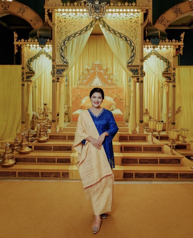 Sebagai pelengkap penampilannya, Kahiyang memadukan baju kurung biru dengan kain ulos berwarna kuning. Foto: dok. Instagram ayanggkahiyang