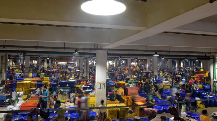 Hiruk Pikuk Pasar Ikan Muara Baru, Tempat Asik Nikmati Seafood Pengunjung menikmati makan malam dengan menu aneka olahan ikan segar di