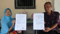 Sri Surantini (kiri) didampingi anak pertamanya Gunawan Joko (kanan) menunjukan surat panggilan pengadilan selaku tergugat di Guwokajen, Sawit, Boyolali, Jawa Tengah, Minggu (28/11/2021). Sri Surantini bersama tiga anaknya digugat ke Pengadilan Negeri (PN) Boyolali oleh dua anak kandungnya yang lain Rini Sarwestri dan Indri Aliyanto terkait pembagian tanah warisan yang terkena pembangunan jalan tol Solo-Yogyakarta.