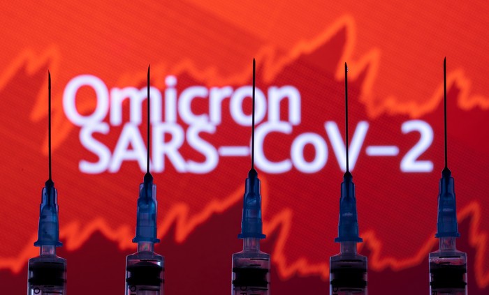 Syringes with needles are seen in front of a displayed stock graph and words Omicron SARS-CoV-2 in this illustration taken, November 27, 2021. REUTERS/Dado Ruvic/Illustration