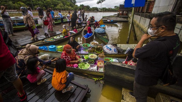Pedagang melayani pembeli di wisata Pasar Terapung Siring Sungai Martapura di Banjarmasin, Kalimantan Selatan, Minggu (28/11/2021). 