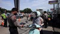 Polisi memeriksa plat kendaraan sepeda motor saat penerapan sistem ganjil genap dalam Pemberlakuan Pembatasan Kegiatan Masyarakat (PPKM) level 3 di kawasan wisata Sentul, Kabupaten Bogor, Jawa Barat.
