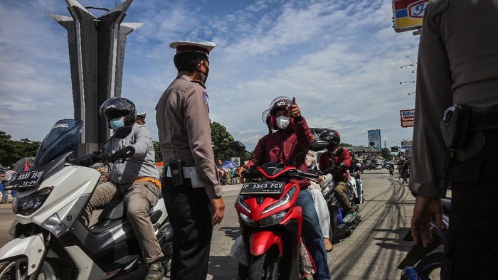 Polisi menghentikan pengendara sepeda motor dengan plat nomor ganjil saat penerapan sistem ganjil genap dalam Pemberlakuan Pembatasan Kegiatan Masyarakat (PPKM) level 3 di kawasan wisata Sentul, Kabupaten Bogor,  Jawa Barat, Minggu (28/11/2021). Pemberlakuan sistem ganjil genap di jalur objek wisata di wilayah Sentul tersebut untuk mengantisipasi kerumunan pada libur akhir pekan sebagai upaya menekan penyebaran COVID-19. ANTARA FOTO/Yulius Satria Wijaya/nym.