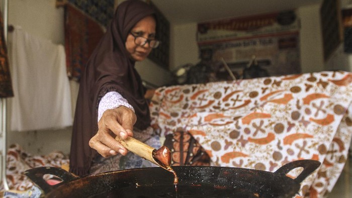 PRODUKSI BATIK DEPOK Pekerja menyelesaikan pembuatan batik tulis di Batik Tradjumas, Pengasinan, Depok, Jawa Barat, Minggu (28/11/2021). Produksi batik khas Kota Depok seperti Gong Si Bolong, Tugu Batu, Belimbing Dewa dan Ikan Hias tersebut mencapai 500 lembar per bulan yang dijual Rp200 ribu hingga Rp2 juta per lembar (2,1 meter) tergantung cara pembuatan dan tingkat kesulitan. ANTARA FOTO/Asprilla Dwi Adha/nym.