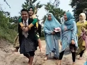 Tak Ada Jembatan, Pengantin Pria di Polman Rela Gendong Istri Seberangi Sungai