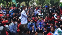 Sambil duduk, Anies terlihat mendengarkan tuntutan perwakilan buruh.