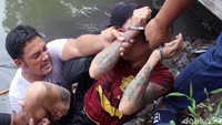 Kedua tangannya tampak diborgol.