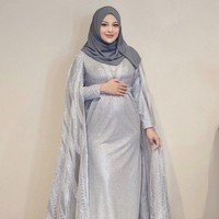 Aurel Hermansyah tampil anggun dan elegan dalam balutan gaun yang membuat baby bump-nya tampak menonjol. Aurel mengenakan dress glitter silver potongan cape pada lengannya, dipadu dengan hijab segi empat warna abu tua. Foto: Dok. Instagram @aurelie.hermansyah.