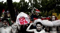 Tampak sejumlah buruh melumurkan tubuhnya dengan cat berwarna silver dan menggotong replika peti mati saat gelar aksi unjuk rasa di depan Gedung Balai Kota Jakarta.