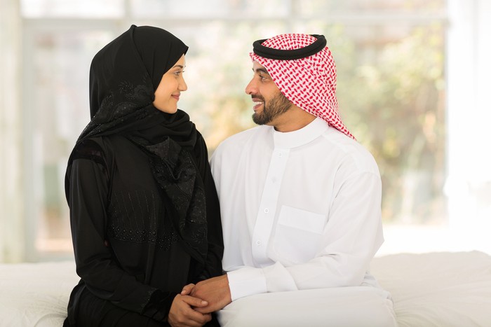 romantic arabic couple sitting on bed