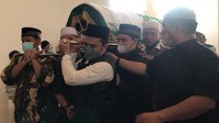 Beberapa orang tampak bergantian mengangkat keranda jenazah Ameer Azzikra. Foto: Hanif Hawari/detikcom