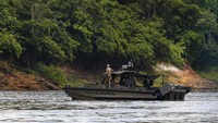 Sebuah kapal motor Polisi Federal berpatroli di sungai setelah lebih dari 60 tongkang pengerukan dibakar oleh petugas IBAMA.