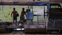 Para penambang ilegal tersebut berjibaku pemadamkan api di kapal-kapal tongkang mereka usai dibakar petugas.
