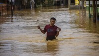Seorang warga beraktivitas di tengah banjir yang merendam kawasan Barabai, Kabupaten Hulu Sungai Tengah, Kalimantan Selatan, Senin (29/11/2021).
