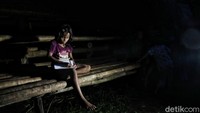Seorang anak beraktivitas di tengah keterbatasan penerangan di Desa Kadu Eta, Kecamatan Kodi Utara, Kabupaten Sumba Barat Daya, Nusa Tenggara Timur, Minggu (14/11/2021).