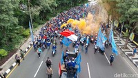 Para buruh yang didominasi menggunakan kaos biru ini menggelar sedikit aksi di Jalan Darmo. Ada sejumlah buruh yang menyalakan suar warna-warni hingga membunyikan klakson. Esti Widiyana/detikcom  
