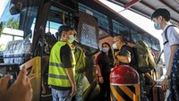 Pelancong naik bus di persimpangan bus sementara Woodlands yang akan mengangkut mereka ke Malaysia dari Singapura. (AP/Toh Ee Ming)