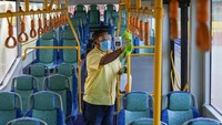 Seorang petugas bus membersihkan interior bus sebelum penumpang naik di terminal bus Larkin di Johor Bahru, Malaysia. (AP/Vincent Thian)