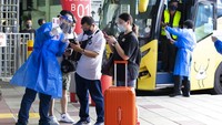 Penumpang tiba dari Singapura di terminal bus Larkin di Johor Bahru, Malaysia. (AP/Vincent Thian)