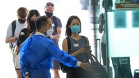 Penumpang tiba dari Singapura di terminal bus Larkin di Johor Bahru, Malaysia. Kedua negara mengatakan batas penyeberangan perbatasan darat akan semakin dilonggarkan untuk memasukkan pelancong umum dan moda transportasi lain selain bus. (AP/Vincent Thian)