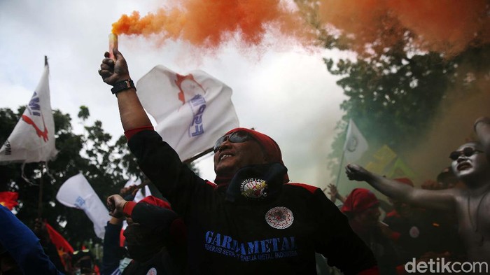 Saat berdemo di depan Balai Kota DKI Jakarta, massa buruh dari Konfederasi Serikat Pekerja Indonesia (KSPI) menyalakan flare berwarna-warni. Begini potretnya.
