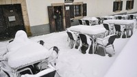 Salju menutupi kursi dan meja sebuah restoran bar di Roncesvalles, Spanyol utara.