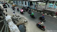 Penampakan tumpukan material batu dan karung pasir yang berada di bahu Jalan Raya Bogor, Kramat Jati, Jakarta Timur, Senin (29/11/2021). Warga berharap material ini segera dibersihkan untuk memperlancar arus lalu lintas.