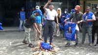 Foto: Tidak lama setelah mengutarakan rasa kecewa, kader membuka baju dan atribut Partai Demokrat. Kader kemudian kompak membakar atribut di tumpukan kayu yang apinya sudah membara