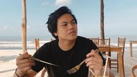 Liburan di Bali, Gangga tak melewatkan sarapan di pinggir pantai. Momen ini semakin spesial dengan menu scrambled egg, baked beans, roti panggang, dan sosis. 